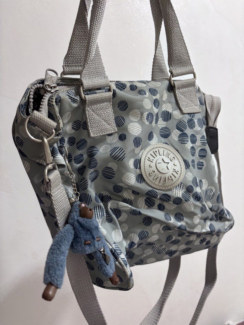 Kipling Grey Polka Dot Tote Bag with Monkey Charm (Category: Tote Bags) located in Quezon City. Submitted by makeitkmn (Listing ID 1453740318, Image 1). Description: - Grey Kipling tote bag - Fun polka dot pattern - Dual top handles - Detachable shoulder strap - Includes iconic Kipling monkey charm - Spacious interior for essentials - Ideal for everyday use.
