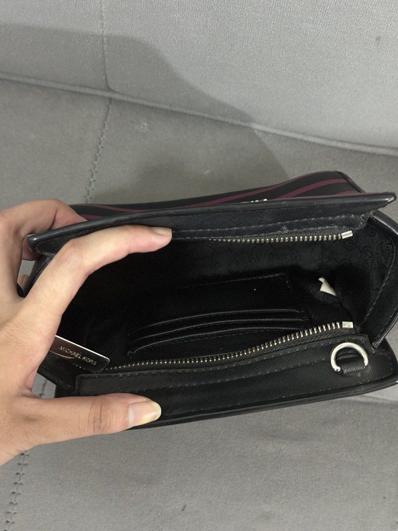 Michael Kors Striped Wallet Pouch (Category: Luxury Bags & Wallets) located in Tarlac. Submitted by via_banana (Listing ID 1453768876, Image 3). Description: - Authentic Michael Kors wallet pouch - Stylish black and maroon stripe design - Secure zippered compartment - Interior card slots for organization - Compact and perfect for essentials - Convenient D-ring attachment on the side - Interior is clean and well-maintained.
