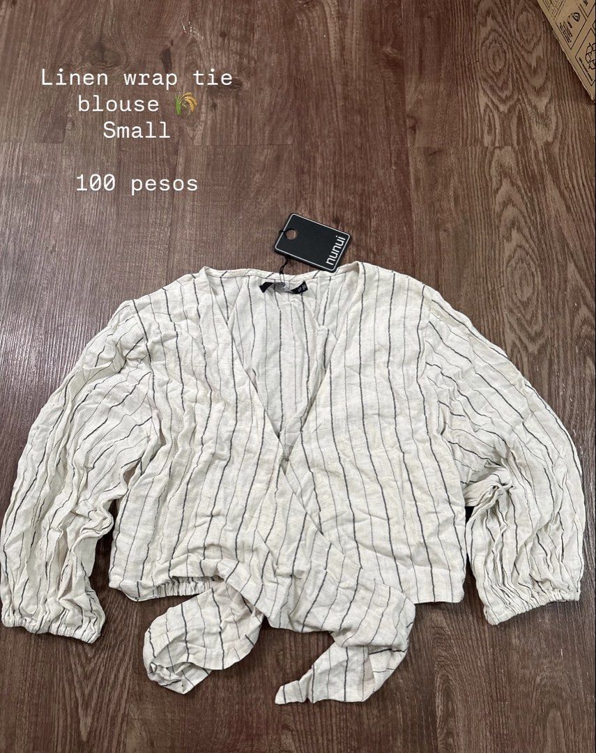 Nunui Linen Wrap Tie Blouse (Category: Blouses) located in Rizal. Submitted by decluttch (Listing ID 1453637184, Image 1). Description: - Cream linen fabric - Thin black stripes - Wrap tie detail at the front - Balloon sleeves with elastic cuffs - Size: Small - Ideal for casual outings.