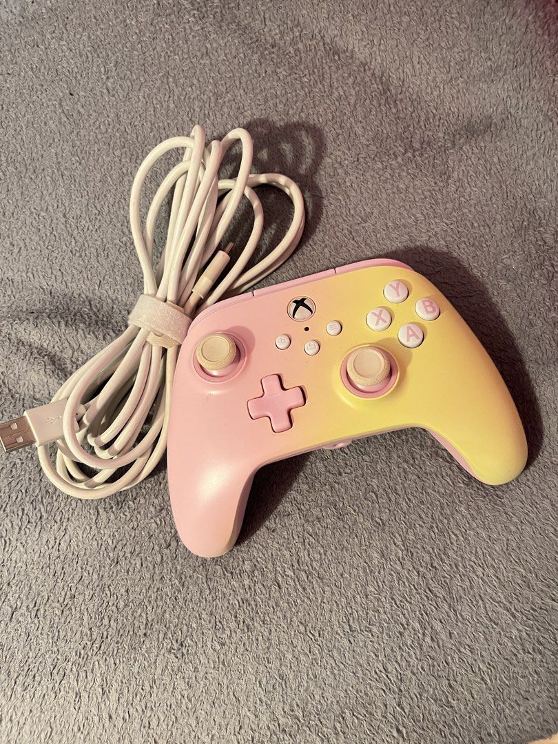 Pink and Yellow Ombre Xbox Controller with Cable (Category: Controllers) located in Paranaque City. Submitted by agirlhasnoname_ (Listing ID 1453773895, Image 1). Description: • Wired Xbox controller • Compatible with PC • Pink & yellow ombre design • Tested and working • Includes white USB cable ‼️ Issues: • Right joystick does not return to center automatically (needs manual adjustment) • Joystick buttons need cleaning or replacement.