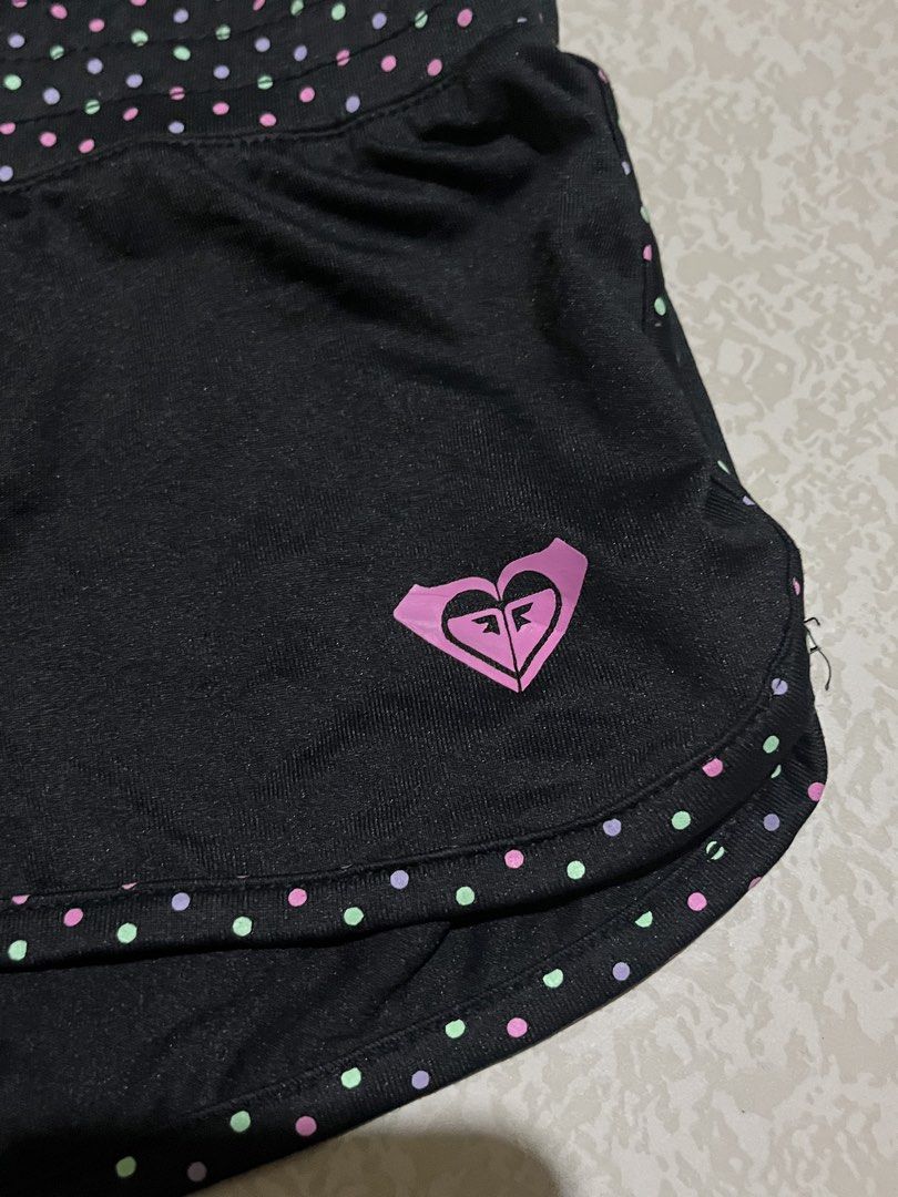 Roxy Black Polka Dot Athletic Shorts Size 10 (Category: Shorts) located in San Isidro, Leyte. Submitted by tigerxdx3580077 (Listing ID 1453699781, Image 2). Description: - Brand: Roxy - Color: Black - Size: 10 - Features: Polka dot waistband and trim, Roxy logo on left leg - Material: Nylon and Spandex blend - Ideal for: Sports and casual wear.