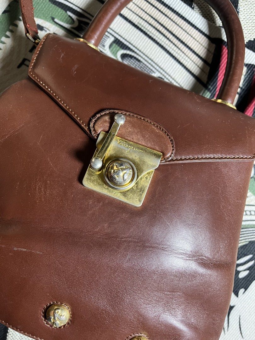 Salvatore Ferragamo Brown Leather Top Handle Bag (Category: Luxury Bags & Wallets) located in Silang. Submitted by yusthrift (Listing ID 1453701822, Image 2). Description: - Vintage Salvatore Ferragamo handbag - Rich brown leather - Iconic Gancini clasp closure - Top handle - Detachable shoulder strap - Signs of wear on leather and hardware (consistent with age) - Classic collectible piece.