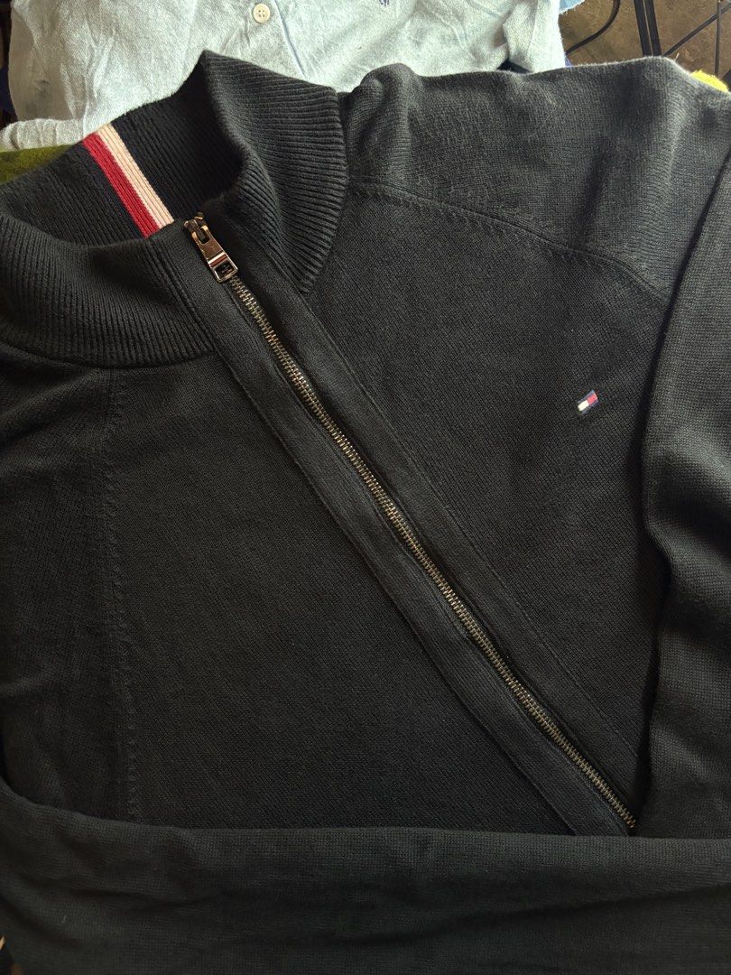 Tommy Hilfiger Black Zip-Up Mock Neck Sweater Jacket (Category: Coats, Jackets and Outerwear) located in San Pedro. Submitted by rjthethrifted. (Listing ID 1453798609, Image 2). Description: Tommy Hilfiger Black Zip-Up Mock Neck Sweater Jacket - Classic black zip-up jacket from Tommy Hilfiger - Mock neck style - Small embroidered logo on the chest - Ribbed collar, cuffs, and hem - Versatile for layering or wearing alone Size on tag Large fit to X