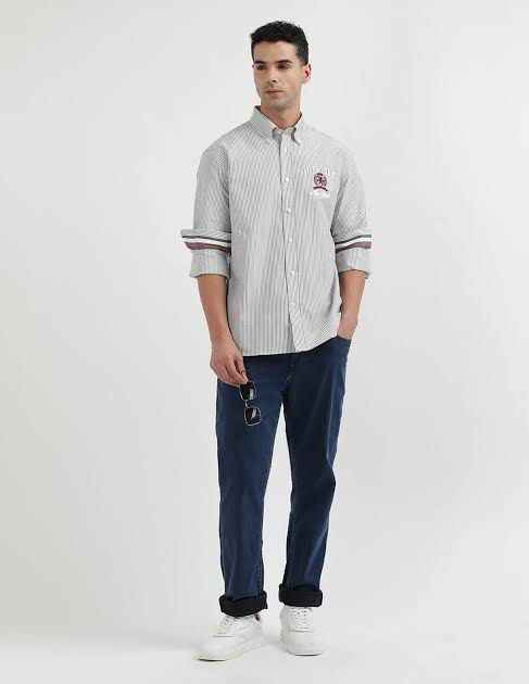 Tommy Hilfiger Striped Button-Down Shirt with Crest Logo (Category: Tshirts & Polo Shirts ) located in Kidapawan. Submitted by azythrift (Listing ID 1453648970, Image 3). Description: - Classic Tommy Hilfiger button-down shirt - Features thin grey and white stripes - Embroidered Tommy Hilfiger crest logo on chest - Striped detail on cuffs - Sharp, clean look - Ideal for casual or smart-casual occasions.