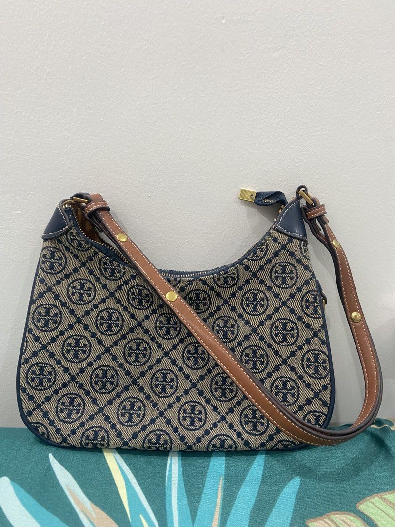 Tory Burch Monogram Shoulder Bag (Category: Luxury Bags & Wallets) located in Quezon City. Submitted by emjen (Listing ID 1453654096, Image 2). Description: - Authentic Tory Burch shoulder bag - Signature monogram print - Navy blue leather trim and strap - Gold-tone hardware with logo zipper pull - Spacious main compartment - Interior branded plaque and QR code tag.