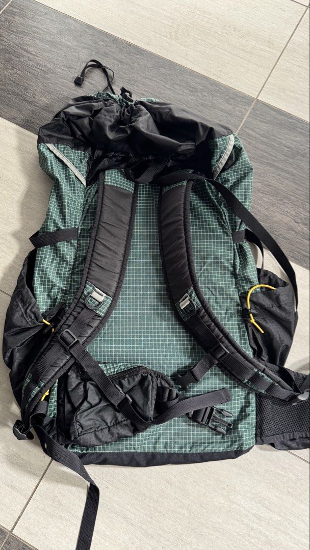 ULA CDT Backpack (Category: Hiking & Camping) located in Kuala Lumpur. Submitted by photophobia (Listing ID 1453789939, Image 3). Description: - Vans ULA CDT backpack - Green and black checkered pattern on top - Black front panel with Vans logo - Multiple external pockets and straps for organization - Secure drawstring closure at the top - Adjustable shoulder straps and hip belt for comfort - Ideal for hiking adventures or travel.