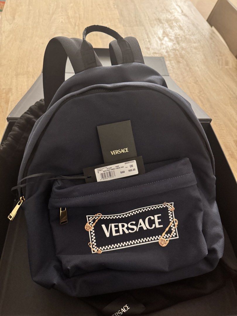 Versace Backpack (Category: Bags & Wallets) located in Singapore. Submitted by larashan (Listing ID 1453788515, Image 3). Description: Versace Safety Pin Logo Backpack – BNIB Brand new in box, never used. Got it as a gift 🎁 * Authentic Versace * Original retail price : SGD $900 * Generous size that can be worn by teens and adults too * Size: 29.5 × 20 × 40 cm * Material: Cotton canvas with calf leather trim * Safety Pin Logo Backpack * Style: 10