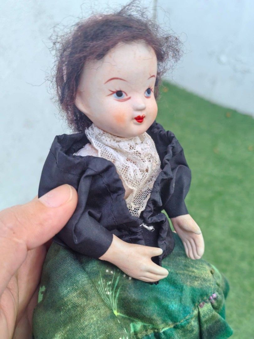 Vintage Porcelain Doll (Category: Vintage Collectibles) located in Cebu City. Submitted by dudes_villanueva (Listing ID 1453744864, Image 2). Description: Vintage Porcelain Doll 📌 likely produced in Europe between the 1950s and 1970s 📌 features a hand-painted porcelain or bisque ceramic head with delicate molded features, a messy dark mohair or synthetic fiber wig, and molded painted shoes or boots. 📌 The clothing represents a regional folklor