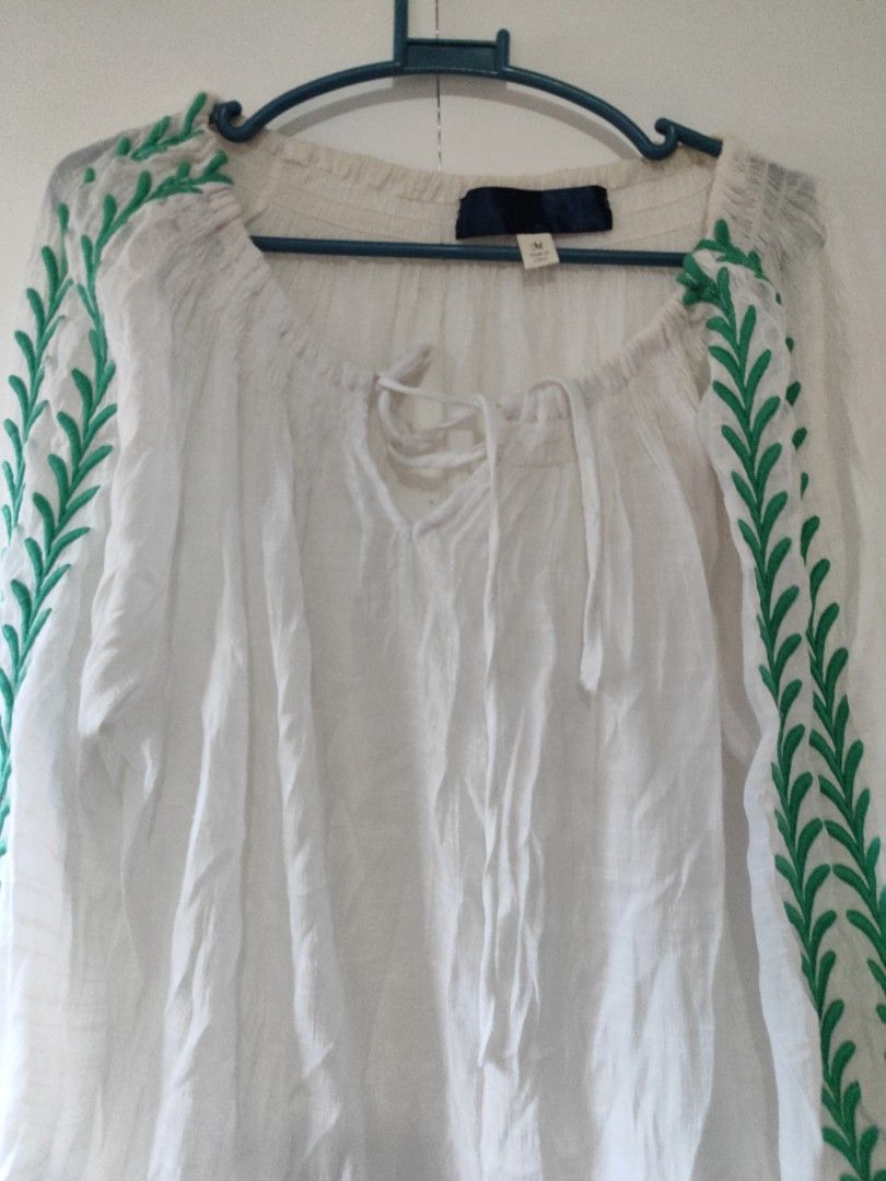 White Embroidered Blouse with Green Leaf Pattern (Category: Blouses) located in Cavite. Submitted by marosa0121 (Listing ID 1453623456, Image 2). Description: -stain on neckline - White peasant-style blouse - Green embroidered leaf pattern on sleeves and neckline - Elasticated cuffs and neckline for a - comfortable fit - Front tie detail for adjustable styling - Lightweight fabric, ideal for warm weather - Versatile piece, easy to dress up or dow