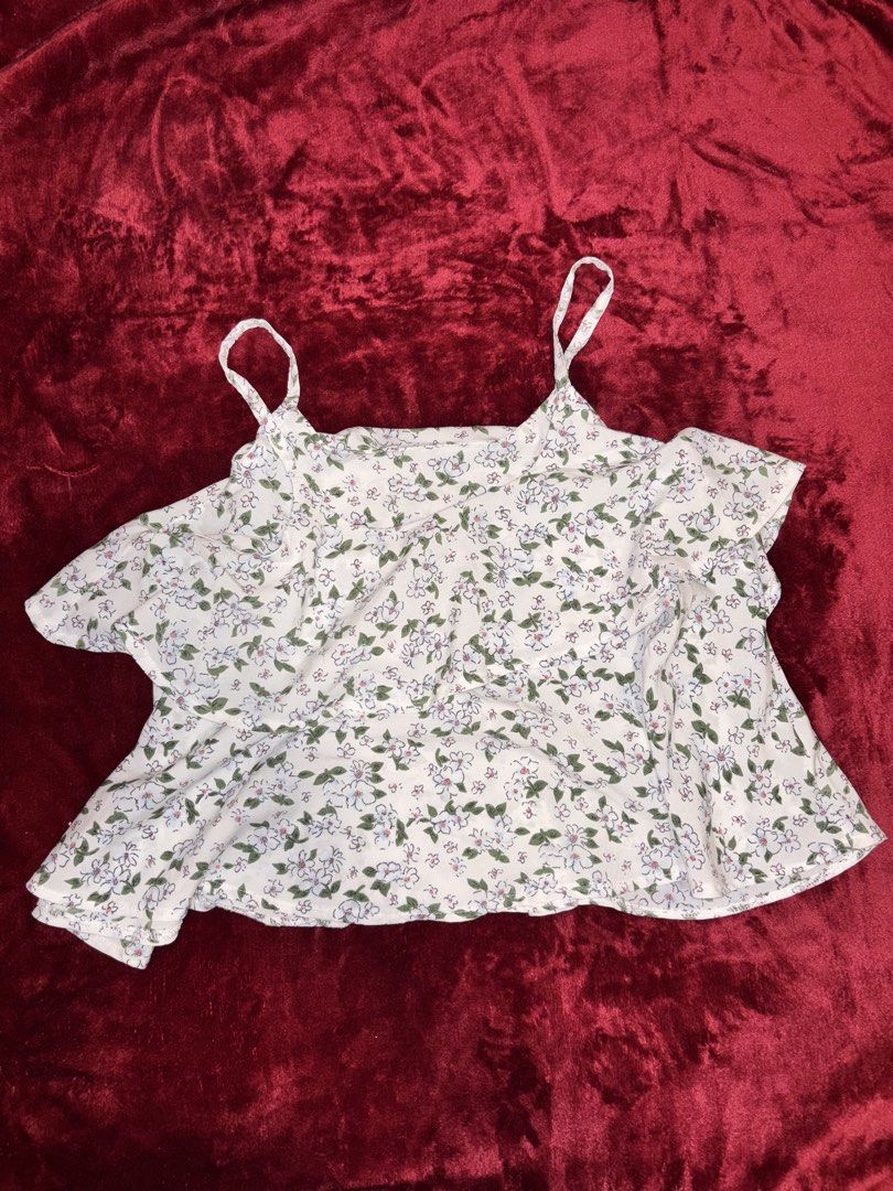 White Floral Strappy Ruffle Top (Category: Sleeveless) located in Batangas. Submitted by puccagirlypop (Listing ID 1453737614, Image 2). Description: Color: White with green and blue floral print Style: Double spaghetti straps with layered ruffle details and a relaxed flared hem Fabric: Lightweight woven fabric Size: Free size (Best fits Small to Medium) A dainty and cottagecore-inspired floral top! Perfect for beach trips, sunny day outs, or cas