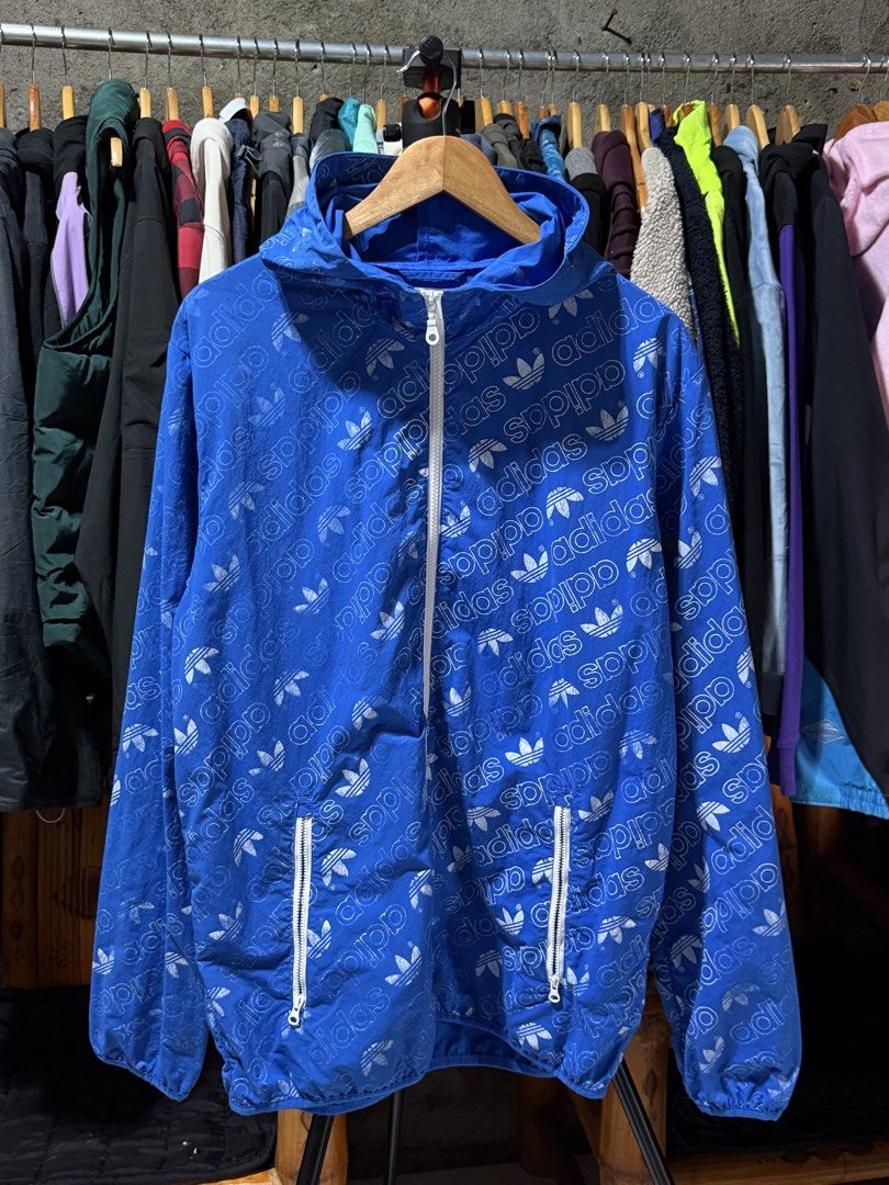 Adidas All Over Print Windbreaker Jacket Blue Size M (Category: Coats, Jackets and Outerwear) located in Bulacan. Submitted by eman02 (Listing ID 1453890850, Image 1). Description: - Cool blue Adidas windbreaker - All-over trefoil logo print - Full zip front - Two zip pockets - Hooded design - Size M - Ideal for casual wear or light workouts.