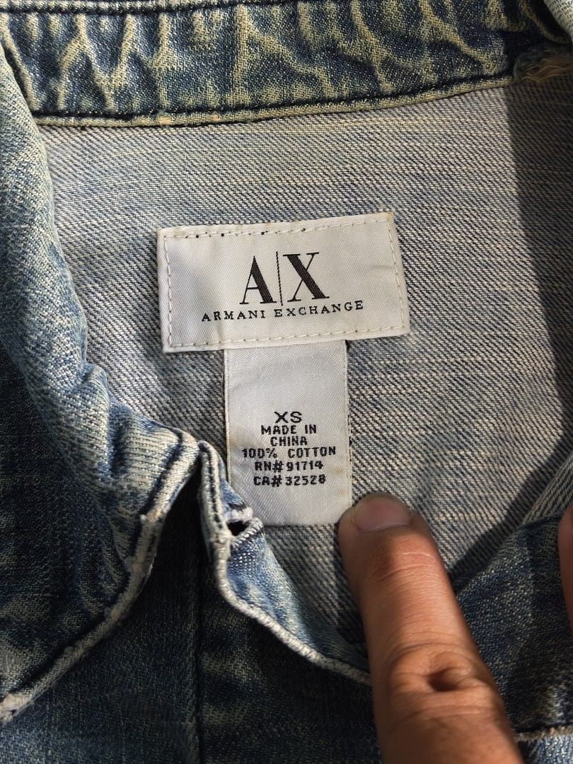 Armani Exchange AX Denim Jacket XS Blue Cotton (Category: Coats, Jackets and Outerwear) located in Floridablanca. Submitted by vintager12 (Listing ID 1453973754, Image 3). Description: - Classic blue denim jacket from Armani Exchange - Made of 100% cotton - Features button closure - Two chest pockets - Ideal for layering - Size: XS.