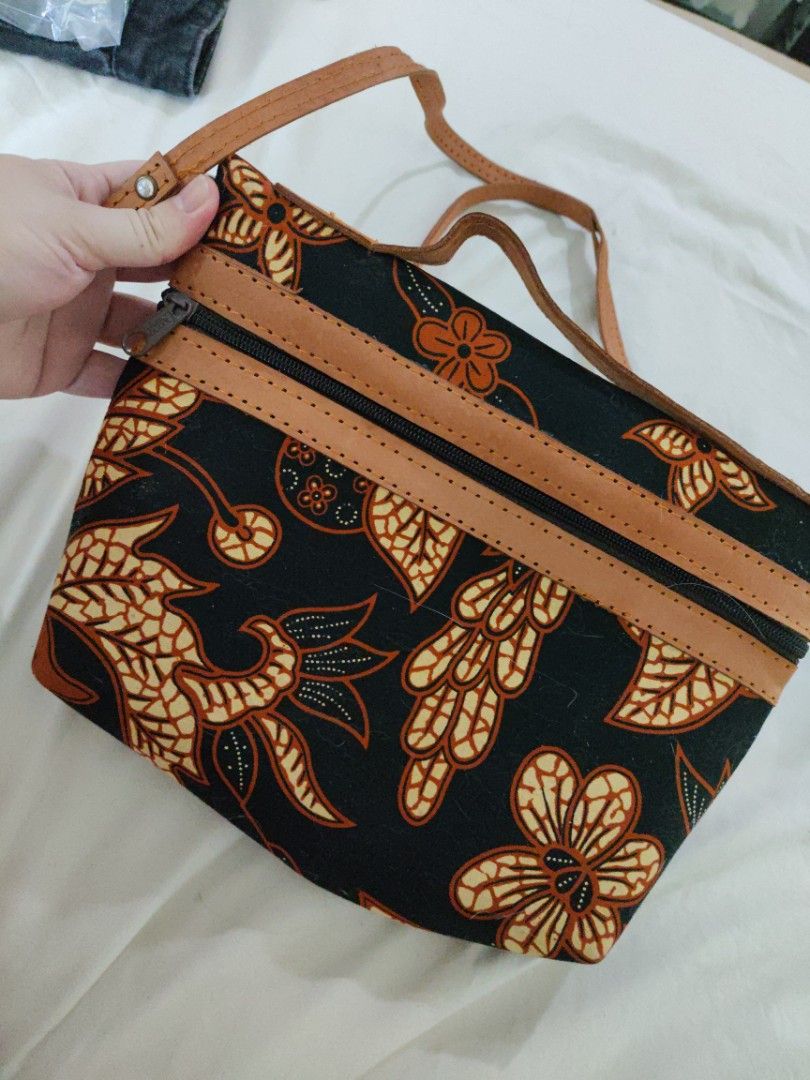 Batik Print Crossbody Bag with Leather Straps (Category: Cross-body Bags) located in Mandaue City. Submitted by regdeclutters (Listing ID 1453843888, Image 2). Description: From Indonesia cross body bag Black solid material. Cute batik print crossbody bag. Features a black background with orange and cream floral patterns. Has leather straps and zipper closures. The interior is lined with dark fabric. Great for carrying essentials. Measures about 
