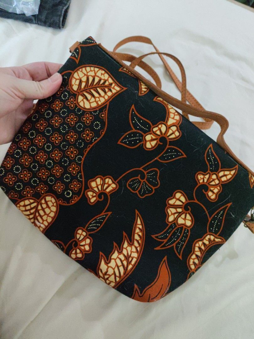 Batik Print Crossbody Bag with Leather Straps (Category: Cross-body Bags) located in Mandaue City. Submitted by regdeclutters (Listing ID 1453843888, Image 3). Description: From Indonesia cross body bag Black solid material. Cute batik print crossbody bag. Features a black background with orange and cream floral patterns. Has leather straps and zipper closures. The interior is lined with dark fabric. Great for carrying essentials. Measures about 