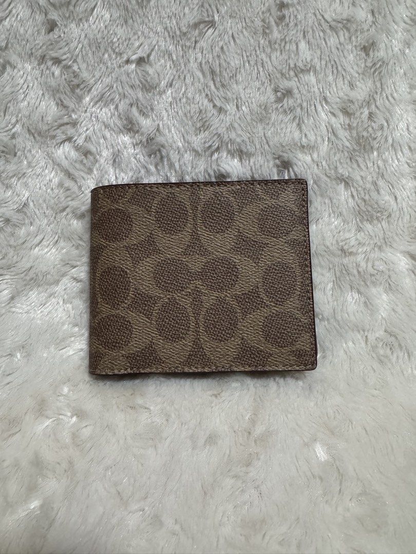 Coach Signature Bifold Wallet (Category: Luxury Bags & Wallets) located in Carmona. Submitted by outletshopper.ph (Listing ID 1453960452, Image 1). Description: - Authentic Coach bifold wallet - Signature 'C' pattern exterior - Multiple card slots inside - Clear ID window - Genuine leather lining - Classic and versatile design - Ideal for everyday use *with very minimal flaws thus selling low *shipping fee shouldered by buyer.