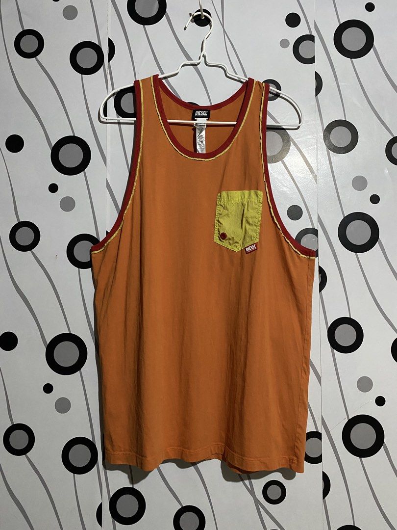 DIESEL Sleeveless Top K297 (Category: Tshirts & Polo Shirts ) located in Cebu City. Submitted by patspickph (Listing ID 1453884695, Image 2). Description: This Diesel men's tank top features a vibrant orange base with contrasting red trim and a contrasting yellow nylon chest pocket. Fearures: Contrasting chest pocket with red button and Diesel logo tag. Size XL on tag Fits L aswell. Dimensions is w21 L31. No issue Excellent Condition.