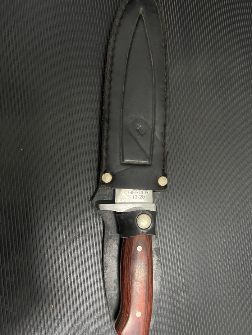 Gerber 13-28 USA Fixed Blade Knife with Sheath (Category: Hiking & Camping) located in Cebu City. Submitted by zershrovv (Listing ID 1453913738, Image 3). Description: - Gerber Fixed Blade Knife - Model: 13-28 - Made in USA - Features a durable wood handle - Sharp, reliable blade - Includes a leather sheath with belt loop - Ideal for outdoor use or as a collector's item.