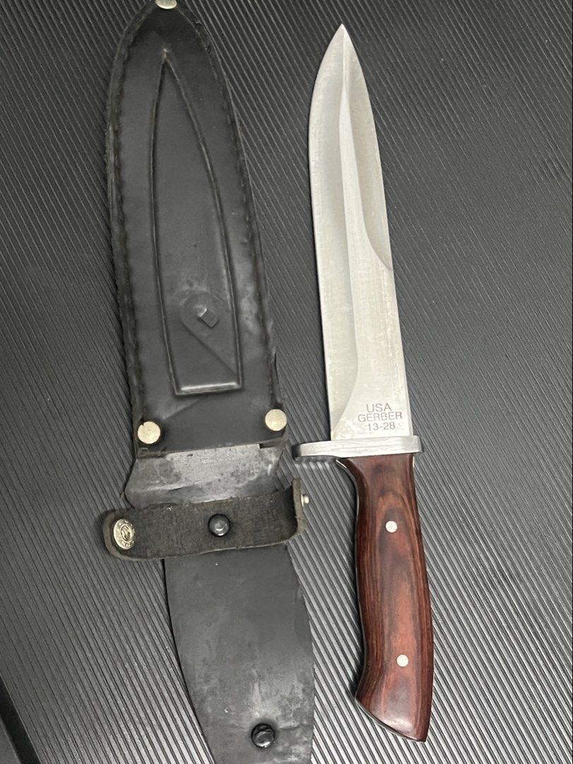 Gerber 13-28 USA Fixed Blade Knife with Sheath (Category: Hiking & Camping) located in Cebu City. Submitted by zershrovv (Listing ID 1453913738, Image 2). Description: - Gerber Fixed Blade Knife - Model: 13-28 - Made in USA - Features a durable wood handle - Sharp, reliable blade - Includes a leather sheath with belt loop - Ideal for outdoor use or as a collector's item.