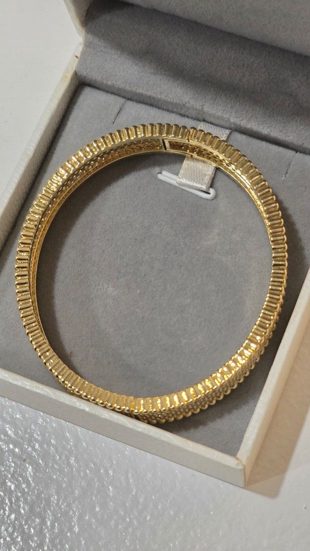 Gold Bangle with Crystals (Category: Bracelets) located in Iloilo. Submitted by stellas21 (Listing ID 1453882287, Image 2). Description: - Sparkly gold bangle - Adorned with small, clear crystals - Features a ribbed texture on the sides - Secure clasp closure plated elegant bangles - Versatile for dressing up or everyday wear - Eye-catching and stylish accessory.