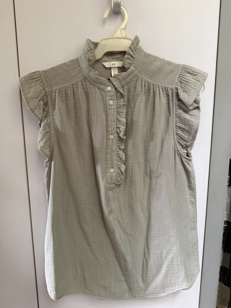 H&M Ruffle Neck Sleeveless Blouse (Blue/Grey) (Category: Blouses) located in Quezon City. Submitted by 0913cartz (Listing ID 1453952166, Image 2). Description: - Cute H&M sleeveless blouse - Features a ruffled neckline - Button details down the front - Adorable flutter sleeves - Versatile for casual or dressy occasions - Available in blue and grey.