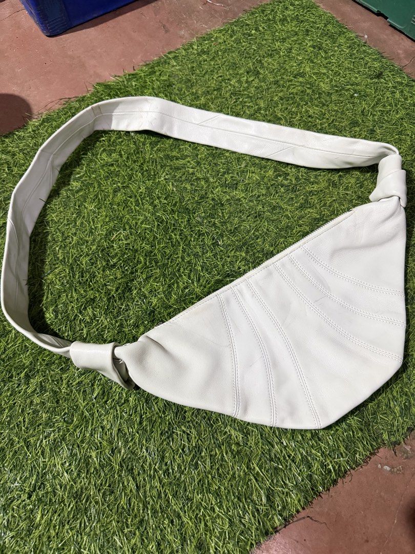 Lemaire Croissant Bag (Category: Cross-body Bags) located in Quezon City. Submitted by macleen17 (Listing ID 1453985298, Image 2). Description: Lemaire Croissant Bag, a popular designer crossbody bag inspired by the shape of a Viennoiserie pastry Curved, multi-panel ergonomic structure resembling a croissant. Wide leather shoulder strap transitioning into distinct knotted side finishes. Sleek, minimalist metal top zipper with a looped puller. -Cu