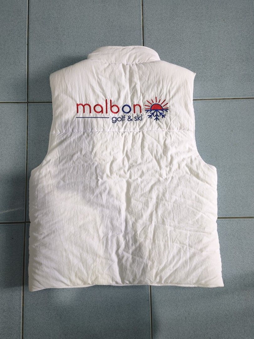 Malbon Golf & Ski White Puffer Vest Size XL (Category: Vests) located in Floridablanca. Submitted by vintager12 (Listing ID 1453973347, Image 2). Description: - White puffer vest from Malbon - Features a sporty red and blue stripe design on the chest - Made of 100% nylon - Ideal for layering and adding a pop of color - Easy to wear - Please check the care label for washing instructions.