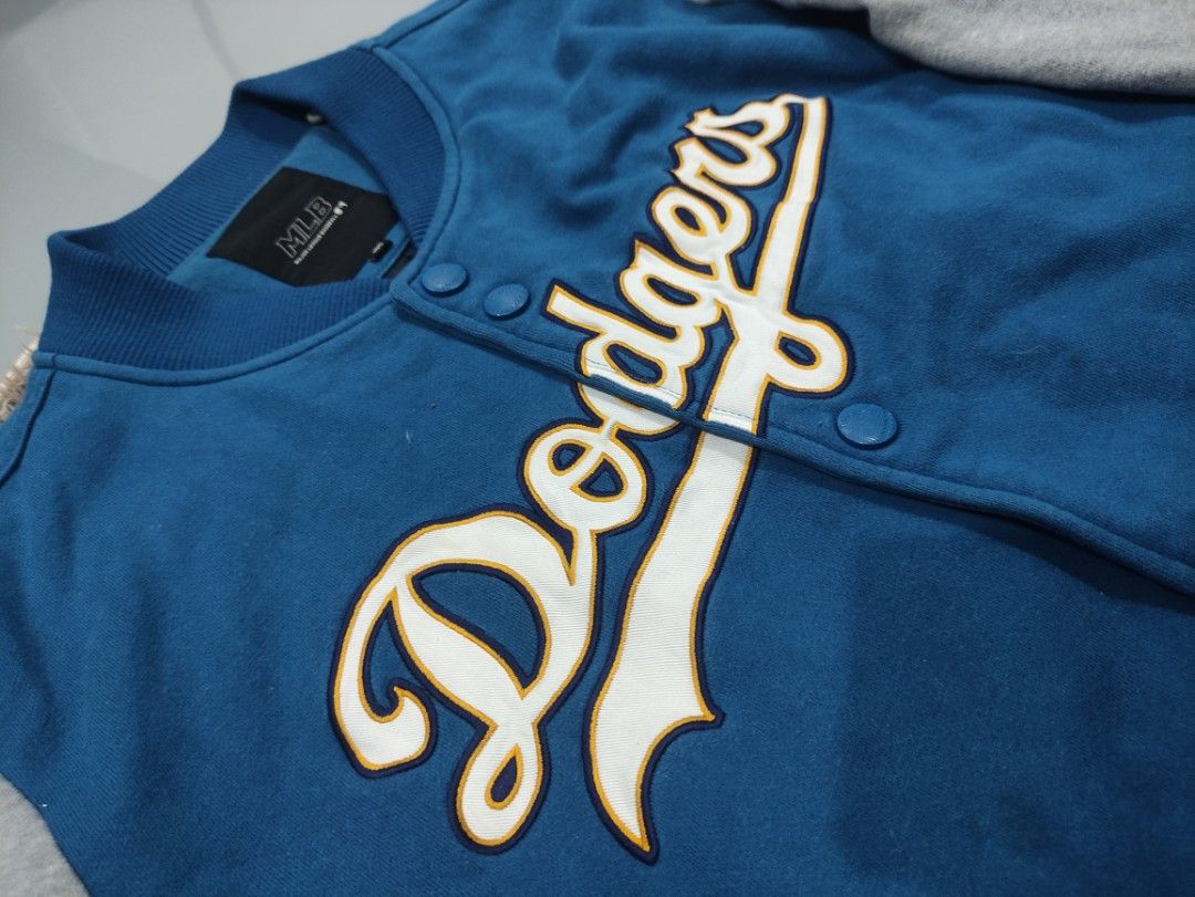 MLB Los Angeles Dodgers Varsity Jacket (Category: Coats, Jackets and Outerwear) located in Manila. Submitted by shellys_collection (Listing ID 1453865079, Image 3). Description: - Classic blue and grey varsity jacket - Features iconic Dodgers and LA logos - Button-up front for easy wear - Ribbed cuffs and hem for a snug fit - Authentic MLB branded tag inside - A must-have for any Los Angeles Dodgers fan!.