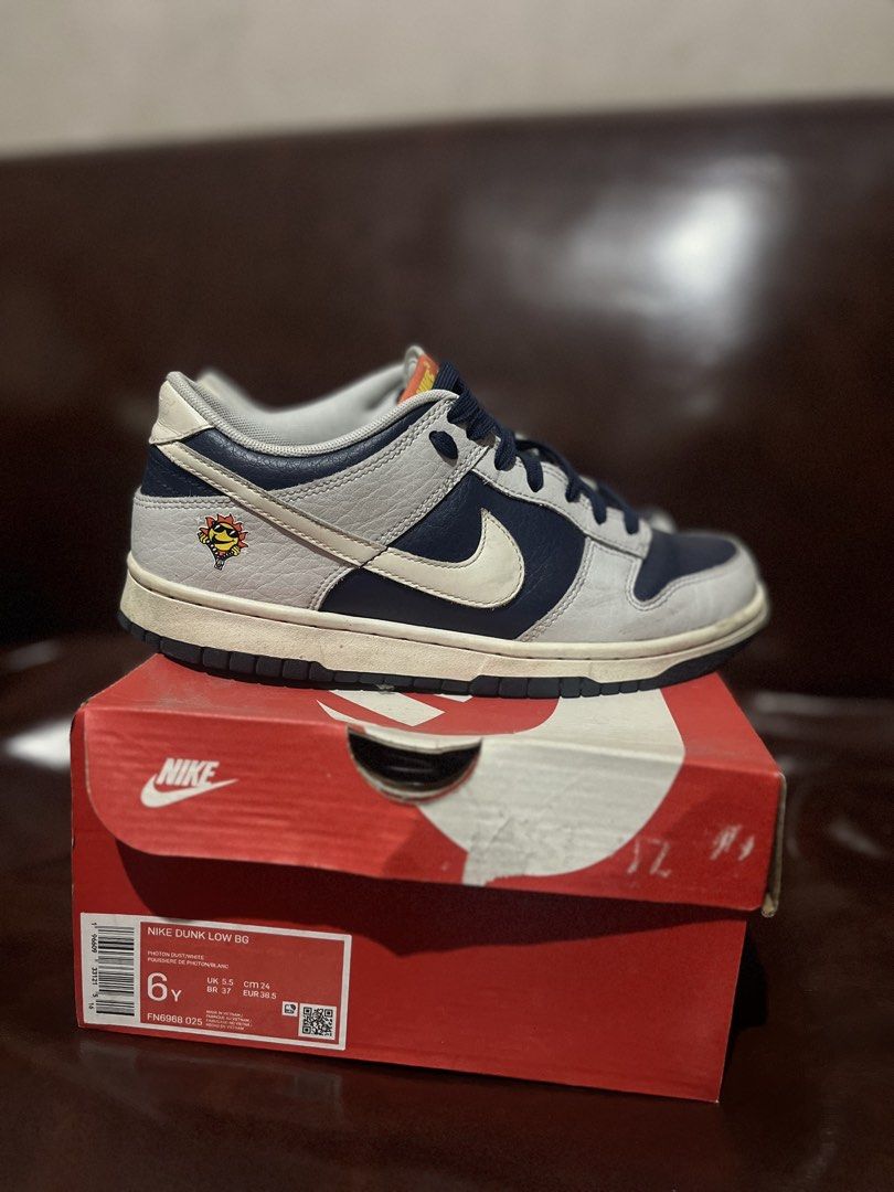 Nike Dunk Low BG (Category: Babies & Kids Fashion) located in Quezon City. Submitted by assdeclutters (Listing ID 1453897659, Image 1). Description: - Colorway: Photon Dust/White - Unique graphic detail on the side (Nike logo turns yellow when sunlight strikes) - Comes with original box Size 6Y, can be worn by adults US 7 women (24 cm). Rfs: decluttering, size is a bit smaller than what I expected. Price is negotiable!!.