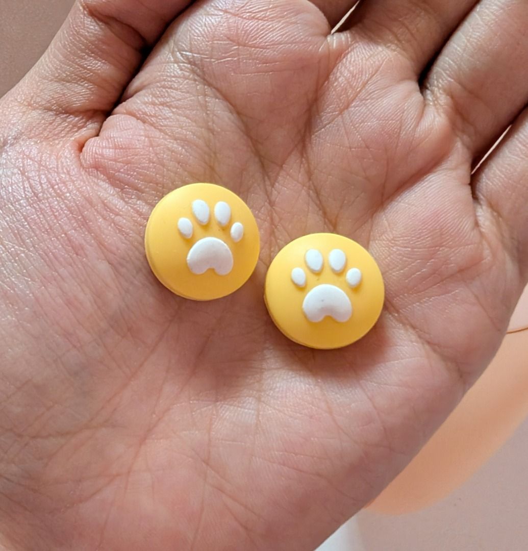 Paw Thumb Grips for Nintendo Switch / Switch Lite - 2pcs Yellow (Category: Controllers) located in Mandaluyong City. Submitted by bbkc.ph (Listing ID 1453631447, Image 3). Description: 🌸 Designed for Nintendo Switch & Switch Lite 🌸 Protects your original analog joysticks from dirt and wear and tear 🌸 May fit 3rd party controllers with small analog joysticks 🌸 Quantity: 2pcs 🌸 Material: Silicone 🌸 This variation has no cardboard packaging 🌸