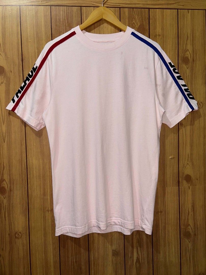 Pink Palace Sideline T-shirt (Category: Formal Shirts) located in Manila. Submitted by zerowastethriftco. (Listing ID 1453838735, Image 2). Description: The Palace Sideline T-Shirt is a highly sought-after streetwear piece from the brand's Fall/Winter 2019 (FW19) collection.Design & FeaturesColorway: A soft, pastel light pink base.Sleeve Details: Vibrant red and royal blue racing-style stripes run down the shoulders and arms.Branding: A bold, ita