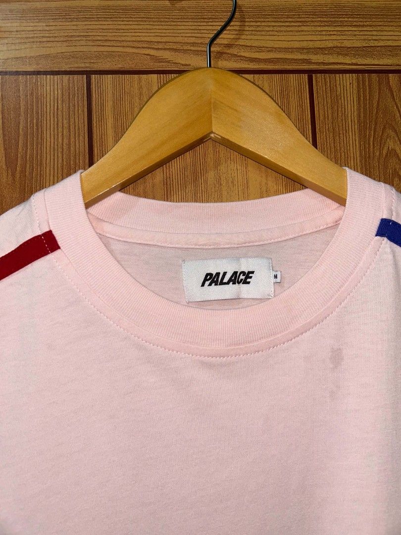 Pink Palace Sideline T-shirt (Category: Formal Shirts) located in Manila. Submitted by zerowastethriftco. (Listing ID 1453838735, Image 3). Description: The Palace Sideline T-Shirt is a highly sought-after streetwear piece from the brand's Fall/Winter 2019 (FW19) collection.Design & FeaturesColorway: A soft, pastel light pink base.Sleeve Details: Vibrant red and royal blue racing-style stripes run down the shoulders and arms.Branding: A bold, ita