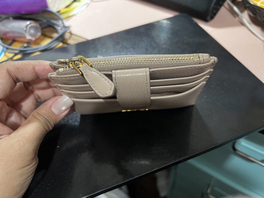 Prada Beige Saffiano Leather Card Holder Wallet (Category: Luxury Bags & Wallets) located in Pasay City. Submitted by msthriftshopp (Listing ID 1453955791, Image 2). Description: - Authentic Prada card holder - Beige saffiano leather - Multiple card slots - Zip compartment - Gold hardware - Small and compact design - Ideal for everyday use.