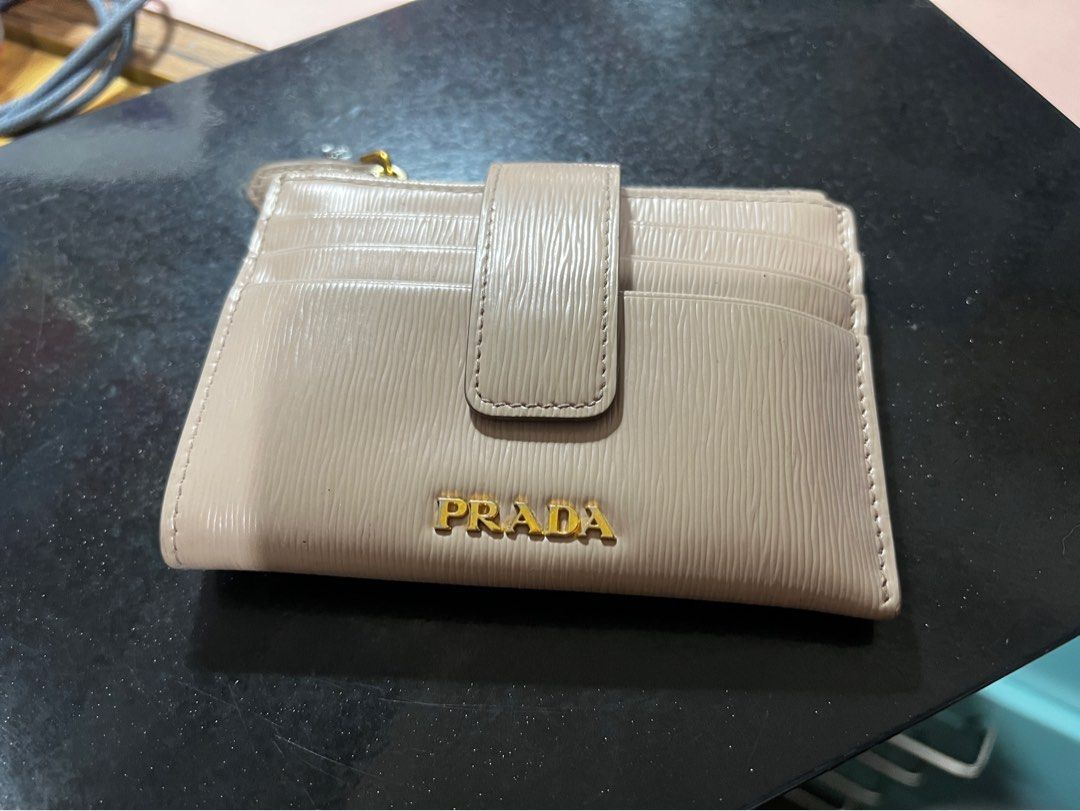 Prada Beige Saffiano Leather Card Holder Wallet (Category: Luxury Bags & Wallets) located in Pasay City. Submitted by msthriftshopp (Listing ID 1453955791, Image 1). Description: - Authentic Prada card holder - Beige saffiano leather - Multiple card slots - Zip compartment - Gold hardware - Small and compact design - Ideal for everyday use.