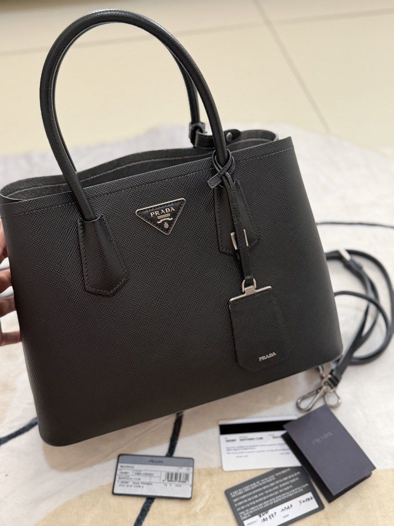 AUTHENTITICPrada Saffiano Leather Tote Bag (Category: Luxury Bags & Wallets) located in Cebu City. Submitted by gdcebu (Listing ID 1453894579, Image 2). Description: - Classic Prada tote bag - Material: Black Saffiano leather - Includes: Shoulder strap and dust bag - Interior: Clean - Exterior: Minimal signs of wear - Style: Timeless, perfect for everyday use.