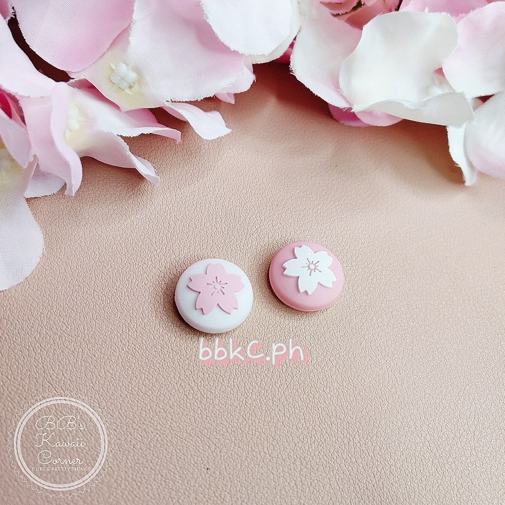 Sakura Thumb Grips for Nintendo Switch / Switch Lite - 2pcs White and Pink combo (Category: Controllers) located in Mandaluyong City. Submitted by bbkc.ph (Listing ID 1453630749, Image 2). Description: 🌸 Designed for Nintendo Switch & Switch Lite 🌸 Protects your original analog joysticks from dirt and wear and tear 🌸 May fit 3rd party controllers with small analog joysticks 🌸 Quantity: 2pcs 🌸 Material: Silicone 🌸 This variation has no cardb
