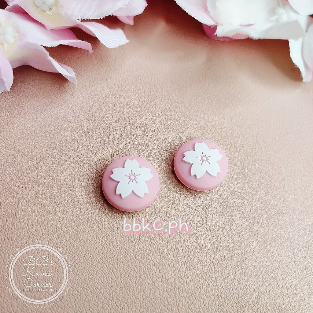 Sakura Thumb Grips for Nintendo Switch / Switch Lite - 2pcs Pink Combo (Category: Controllers) located in Mandaluyong City. Submitted by bbkc.ph (Listing ID 1453630451, Image 2). Description: 🌸 Designed for Nintendo Switch & Switch Lite 🌸 Protects your original analog joysticks from dirt and wear and tear 🌸 May fit 3rd party controllers with small analog joysticks 🌸 Quantity: 2pcs 🌸 Material: Silicone 🌸 This variation has no cardboard packa