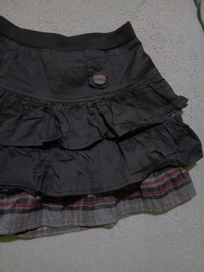 Tiered Ruffle Skirt with Plaid Trim (Category: Skirts) located in Bulacan. Submitted by esecleus (Listing ID 1453813899, Image 2). Description: - Dark grey tiered skirt - Ruffled layers - Plaid trim at bottom hem - Comfortable elastic waistband - Two decorative buttons on front - Fun and flirty style.