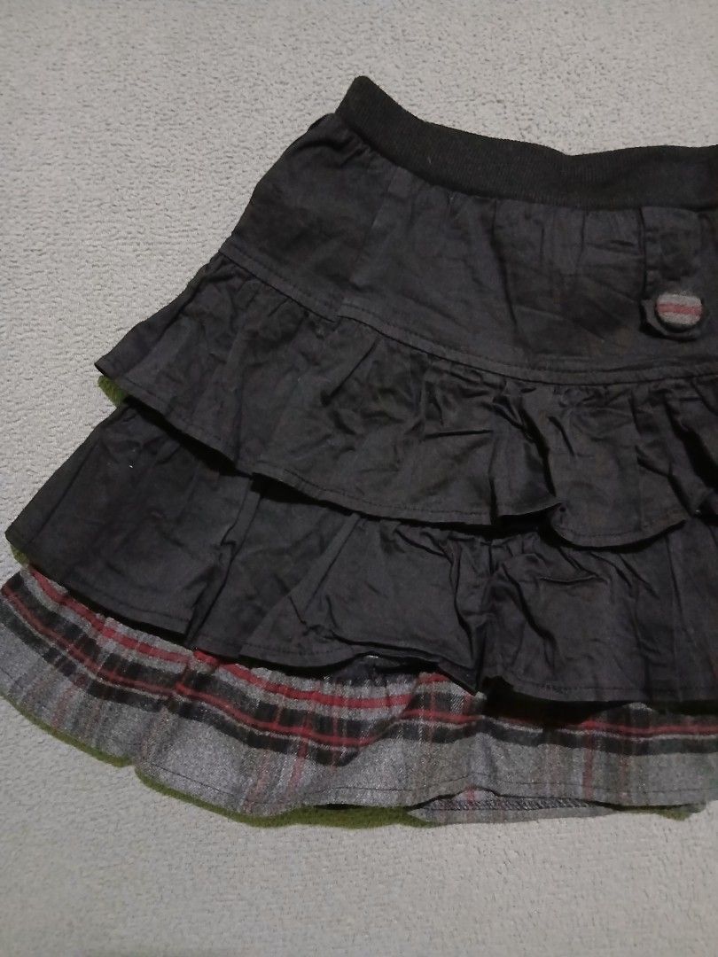 Tiered Ruffle Skirt with Plaid Trim (Category: Skirts) located in Bulacan. Submitted by esecleus (Listing ID 1453813899, Image 3). Description: - Dark grey tiered skirt - Ruffled layers - Plaid trim at bottom hem - Comfortable elastic waistband - Two decorative buttons on front - Fun and flirty style.