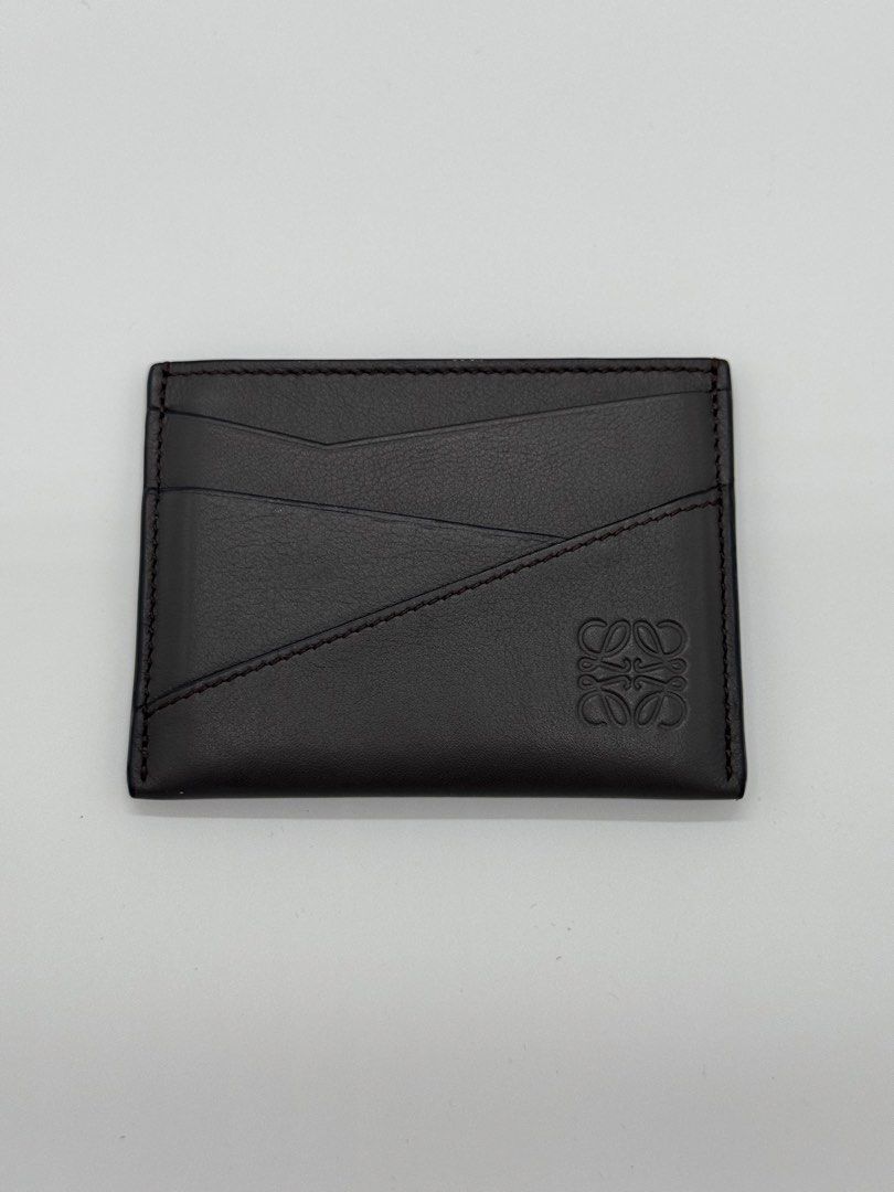 Authentic Loewe Puzzle Cardholder in Dark Grey (Category: Luxury Bags & Wallets) located in Mandaluyong City. Submitted by primecollections.ph (Listing ID 1454038333, Image 2). Description: Loewe Puzzle Cardholder Guaranteed authentic. Money back if proven fake. Selling for 18,000 only. Slightly nego. Condition: 9.2-9.5/10 | Very good condition Directly bought from the store in Marina Bay, Singapore. Barely used, only creases from the cards. Plea
