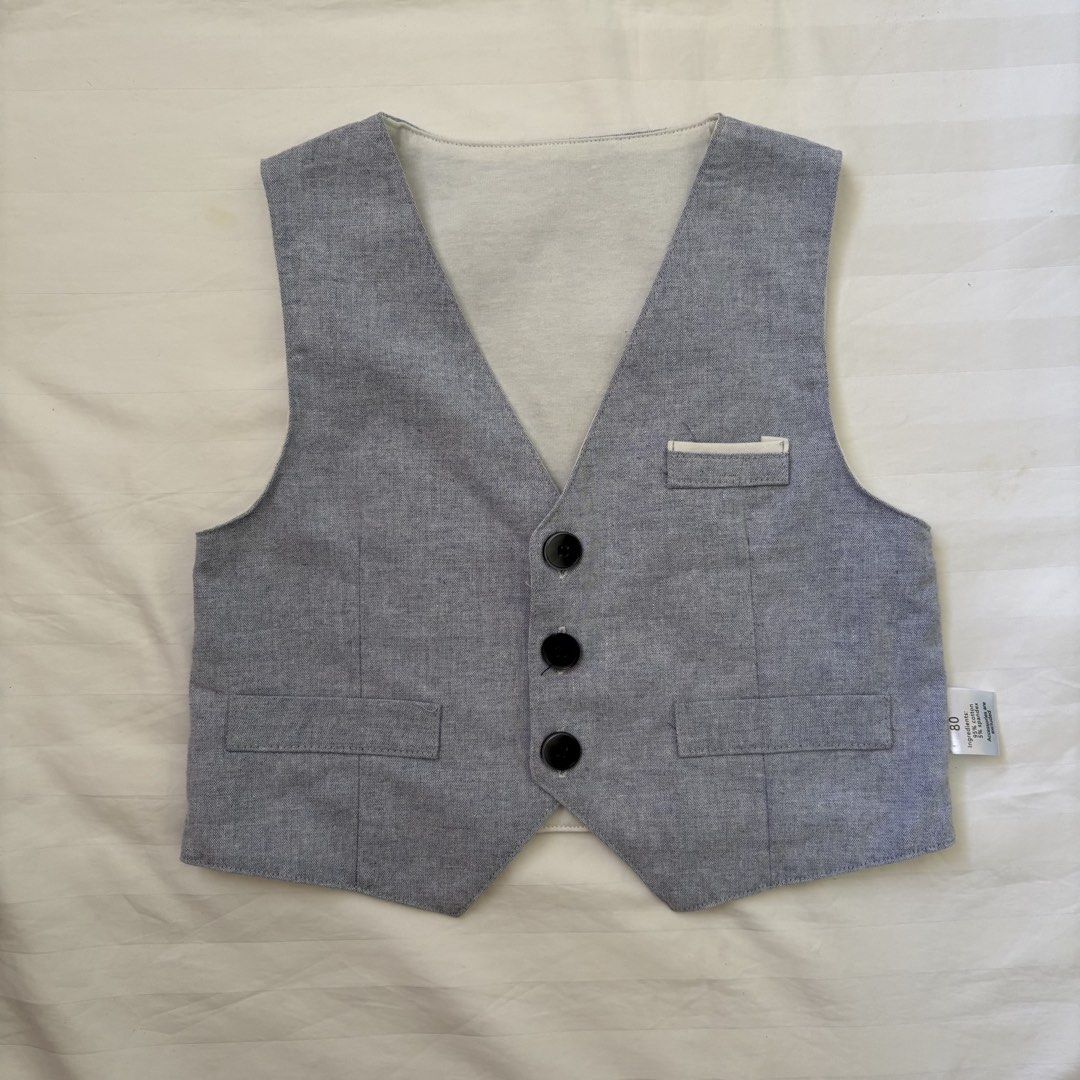 Baby Grey Vest (Category: Babies & Kids Fashion) located in Nabua. Submitted by fourpreloved_ (Listing ID 1454149847, Image 1). Description: - Grey baby vest, perfect for layering. - Size: 80 - Material: Soft 95% Cotton, 5% Spandex blend - Features: Three black button front closure - Pockets: Two at the bottom, one small chest pocket - Detail: Chic black strap detail on the back.