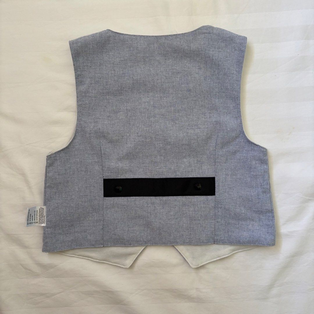Baby Grey Vest (Category: Babies & Kids Fashion) located in Nabua. Submitted by fourpreloved_ (Listing ID 1454149847, Image 3). Description: - Grey baby vest, perfect for layering. - Size: 80 - Material: Soft 95% Cotton, 5% Spandex blend - Features: Three black button front closure - Pockets: Two at the bottom, one small chest pocket - Detail: Chic black strap detail on the back.