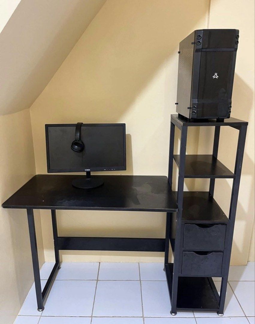 Black Computer Desk with Storage Shelf (Category: Tables & Sets) located in San Juan City. Submitted by superash (Listing ID 1454116197, Image 1). Description: - Black computer desk and matching shelf unit - Shelf features 3 tiers and 2 storage drawers - Includes a black PC tower (placed on shelf) - Ideal for home office or gaming setup - Minor scuffs present on desk surface.