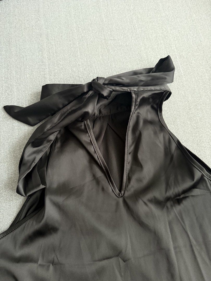 Black Halter Neck Top with Tie Detail (Category: Sleeveless) located in Tuguegarao City. Submitted by Jarah (Listing ID 1454079257, Image 3). Description: - Chic satin-like black top - Elegant halter neck with adjustable back tie - Flattering V-neck cutout detail - Sleeveless design with a stylish wide hem - Perfect for both casual and dressy looks.
