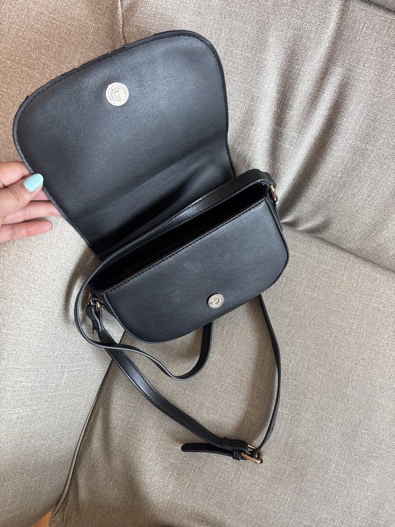 Black Saddle Crossbody Bag with Gold Clasp (Category: Cross-body Bags) located in Paranaque City. Submitted by jujudeclutterss (Listing ID 1454023978, Image 2). Description: - Bought from Malaysia - Cute black saddle bag - Secure gold clasp closure - Adjustable strap for comfort - Spacious main compartment - Fits your daily essentials (phone, wallet, keys) - Clean interior - Minor signs of wear on the exterior, adding character - Ideal for everyd
