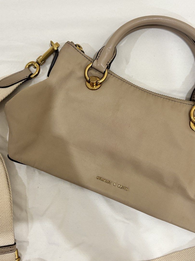 Charles & Keith Taupe Nylon Top Handle Bag with Strap (Category: Shoulder Bags) located in Marikina City. Submitted by beadc (Listing ID 1454160150, Image 2). Description: - Brand: Charles & Keith - Color: Taupe - Material: Nylon - Features: Top handles, detachable crossbody strap - Hardware: Gold details - Closure: Zip - Condition: Minor pink marks on the front (as pictured) - Ideal for: Everyday use.