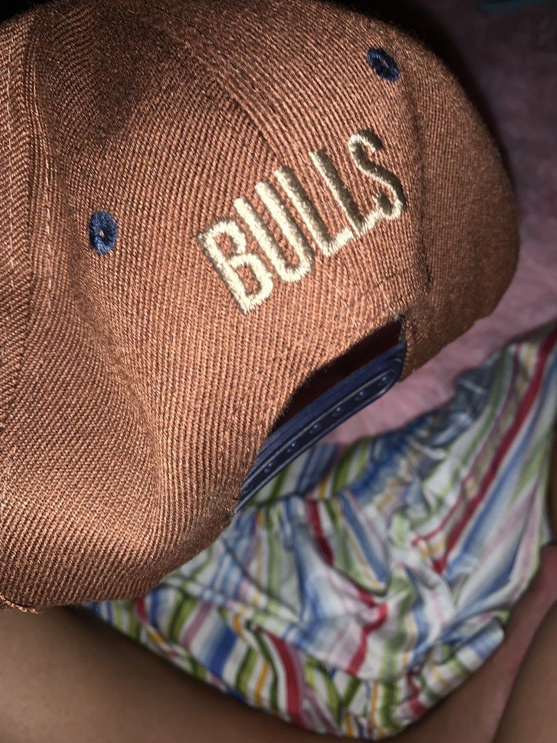 Chicago Bulls Snapback Cap (Category: Caps & Hats) located in Binan City. Submitted by kariray_shop (Listing ID 1454066398, Image 2). Description: - Brown and navy Chicago Bulls snapback cap - Features the classic Bulls logo on the front - 'BULLS' embroidered on the back - Flat brim design - A must-have for any Chicago Bulls fan!.