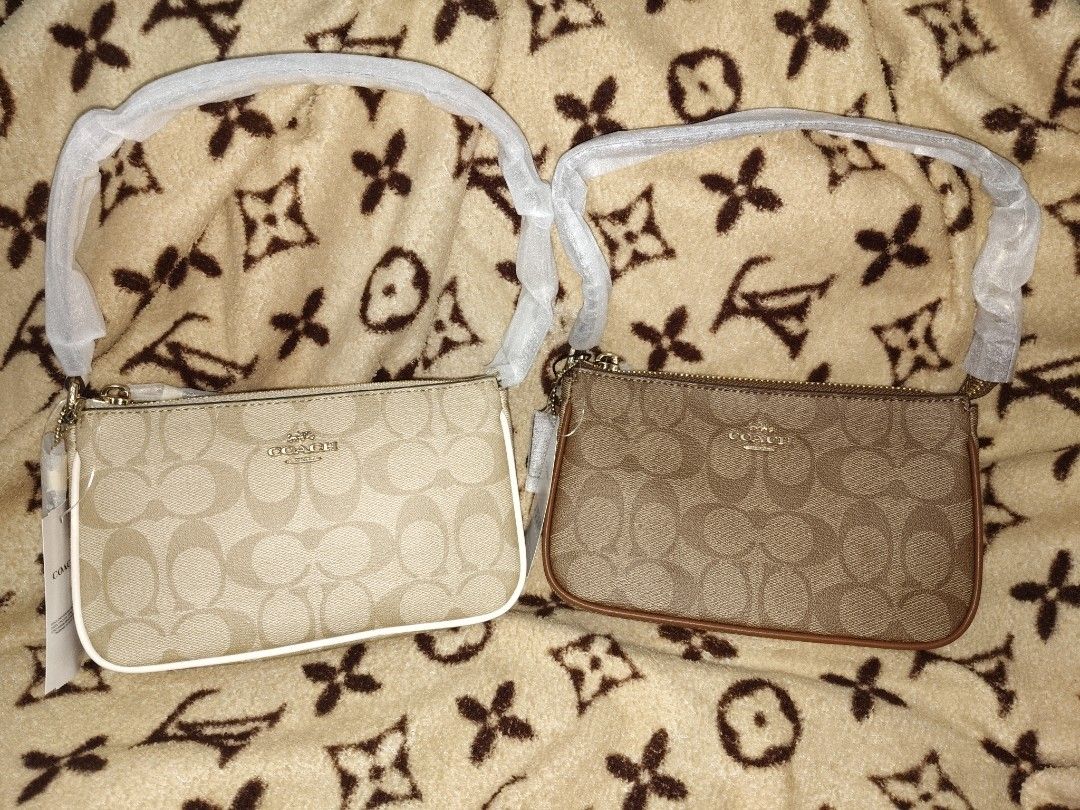 Coach Signature Canvas Wristlet Set (Category: Luxury Bags & Wallets) located in San Juan City. Submitted by swiftfox.62e2f4 (Listing ID 1454070591, Image 1). Description: - Two Coach wristlets in signature C pattern - One light khaki with white trim - One classic brown with brown leather trim - Both feature a wrist strap - Zipper closure for security - Ideal for organizing essentials or standalone use.