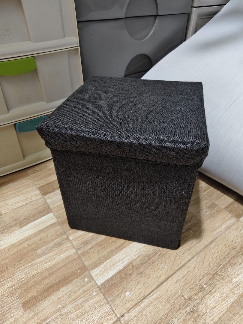 Dark Grey Fabric Storage Ottoman Footrest Stool (Category: Chairs) located in Makati City. Submitted by abegailbrezuela (Listing ID 1454124995, Image 2). Description: - Dark grey fabric storage ottoman - Versatile: use as a footrest or extra seating - Lid lifts for convenient internal storage - Folds flat for easy storage when not in use - Perfect for organizing clutter - Approximate dimensions: 15" x 15" x 15".