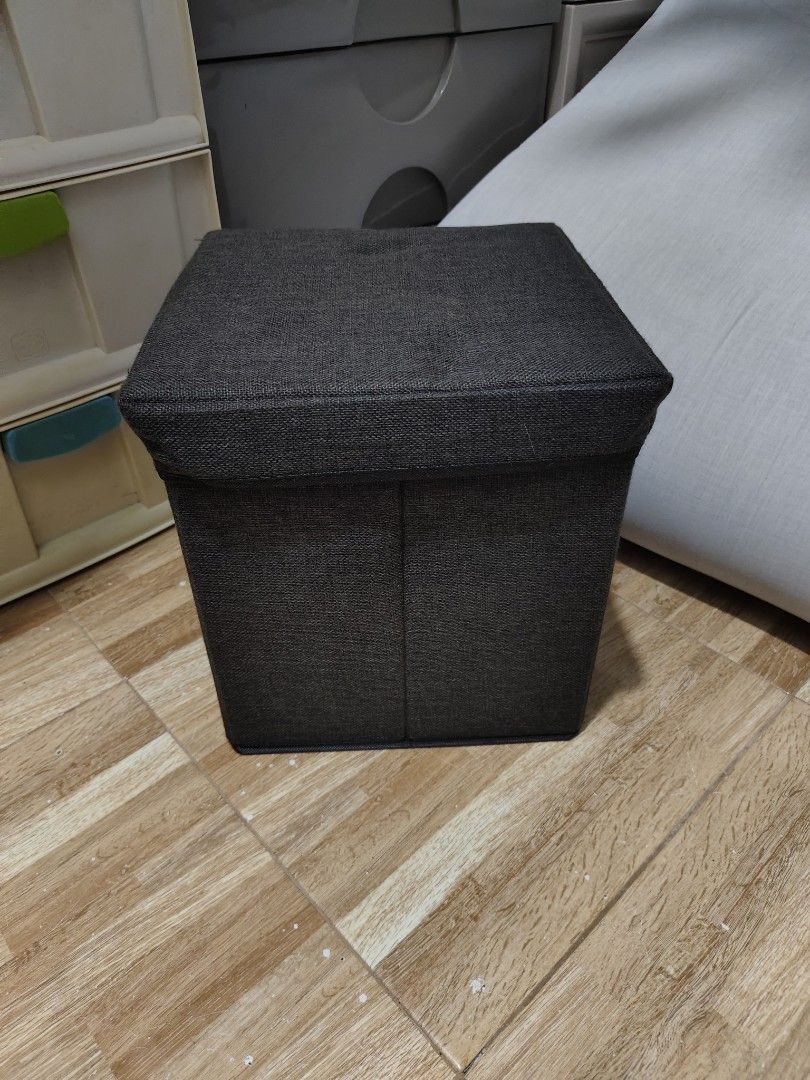 Dark Grey Fabric Storage Ottoman Footrest Stool (Category: Chairs) located in Makati City. Submitted by abegailbrezuela (Listing ID 1454124995, Image 3). Description: - Dark grey fabric storage ottoman - Versatile: use as a footrest or extra seating - Lid lifts for convenient internal storage - Folds flat for easy storage when not in use - Perfect for organizing clutter - Approximate dimensions: 15" x 15" x 15".