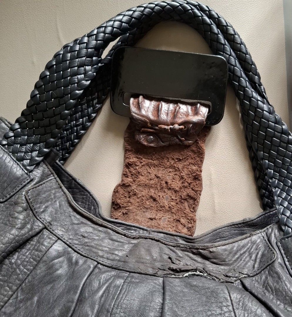 Dark Grey Leather Hobo Bag with Braided Straps (Category: Shoulder Bags) located in Don Carlos. Submitted by PphiXi_Finds (Listing ID 1454145686, Image 2). Description: - Cool black leather hobo bag - Braided straps for a stylish touch - Unique textured buckle detail on the front with crocodile skin leather flap - Black fabric interior lining - Interior zippered pocket for security - Interior slip pocket for easy access - Spacious enough for all 